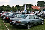 BMW 7er-Reihe auf Pauls Bauernhof; im Hintergrund eine groe Forums-Fahne