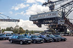 Gruppenfoto mit den teilnehmenden 7er-BMWs in der Arena der Ferropolis, im Hintergrund der Mad Max Eimerkettenbagger