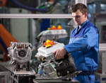 BMW Werk Landshut: Produktion elektrische Antriebssysteme BMW i: Ein Mitarbeiter montiert die Leistungselektronik eines Elektromotors.