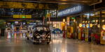 MotorWorld München, hauseigener VW Transporter, rechts: historische Zapfsäulen, restauriert, zum Verkauf