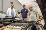 Rhein-Ruhr-Stammtisch im Mai 2026: Mathias ('ktholzi'), Oliver ('Olli-Knolli') und Heiko ('Heiko237') am V12-Motor des 750iL (E32) von Mathias